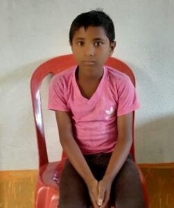 A young boy sitting on top of a red chair.