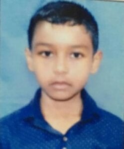 A young boy is wearing a blue shirt.