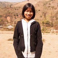 A young girl standing in front of some hills