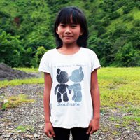 A girl standing in front of some trees