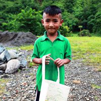 A young boy holding a bag of food.