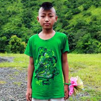A young boy in green shirt holding a pink umbrella.