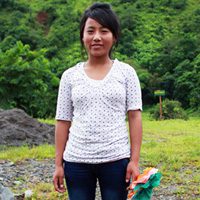 A woman standing in front of some trees