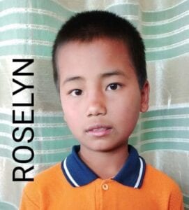 A young boy with blue eyes and an orange shirt.