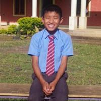 A young boy sitting on top of a bench.