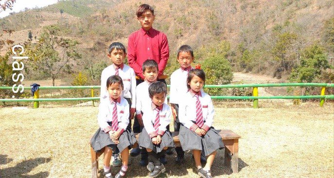 A group of children sitting on top of a bench.