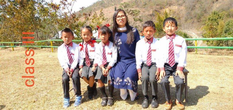 A woman sitting on the ground with several children.