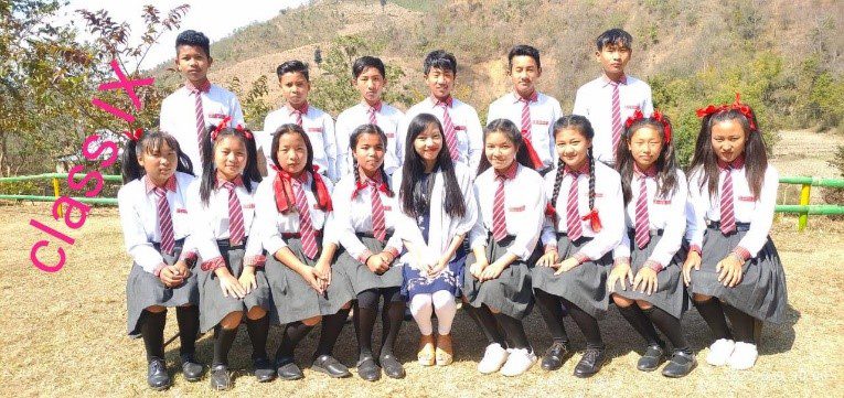 A group of people in school uniforms posing for a picture.
