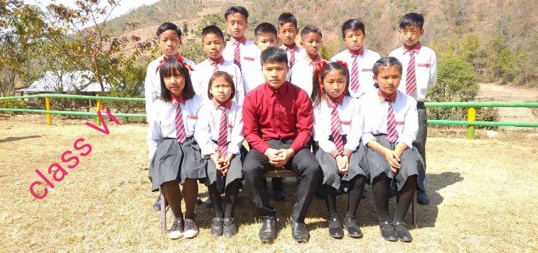 A group of children in school uniforms posing for the camera.