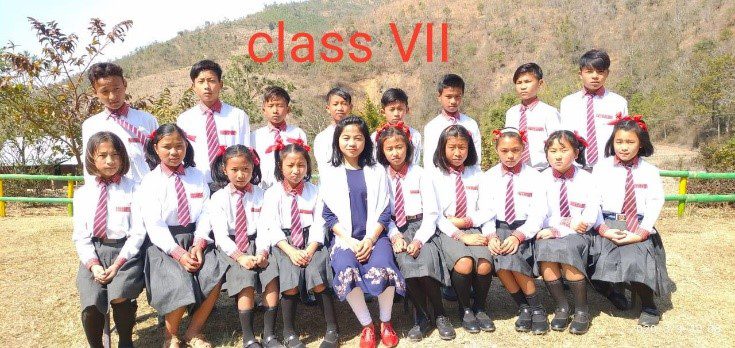 A group of students in school uniforms posing for the camera.