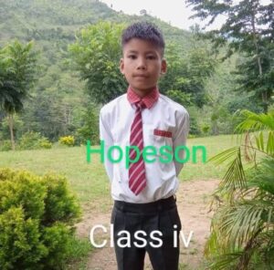 A young boy in a tie and shirt standing outside.