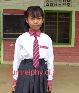 A girl in school uniform standing outside of a building.