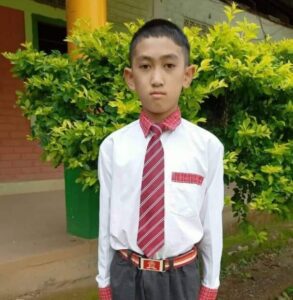 A young boy in a red tie and white shirt.