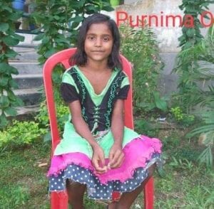 A girl sitting on top of a red chair.