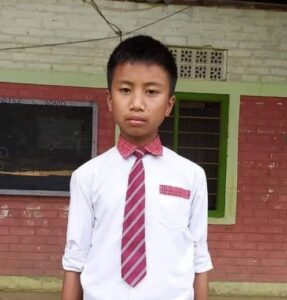 A young boy wearing a tie and white shirt.