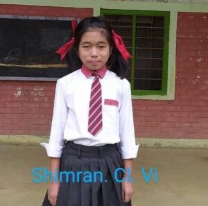A girl in school uniform standing outside of a building.