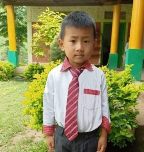 A young boy wearing a tie and dress shirt.