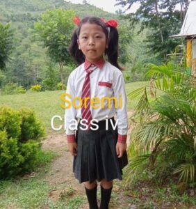 A girl in school uniform standing on the side of a road.
