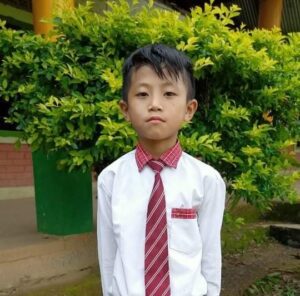 A young boy in a white shirt and red tie.