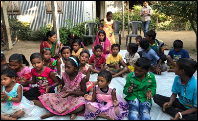 A group of children sitting on the ground.