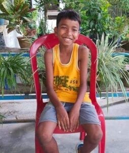 A boy sitting on top of a red chair.
