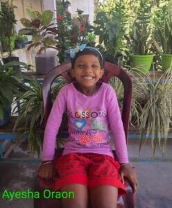 A young girl sitting on top of a chair.