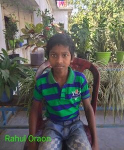 A young boy sitting in a chair outside.