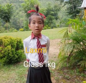 A young girl in school uniform standing outside.