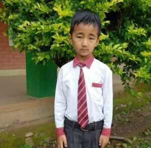 A young boy in a tie and dress shirt.