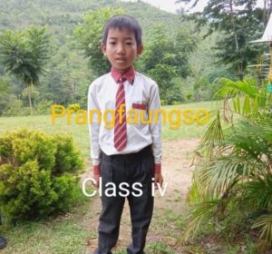 A young boy in a tie standing outside.
