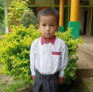 A young boy in a white shirt and red tie.