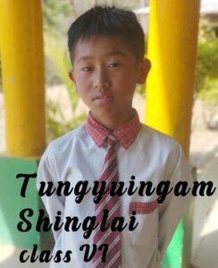 A young boy wearing a tie and standing in front of yellow pillars.