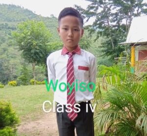 A young boy wearing a red tie and black pants.