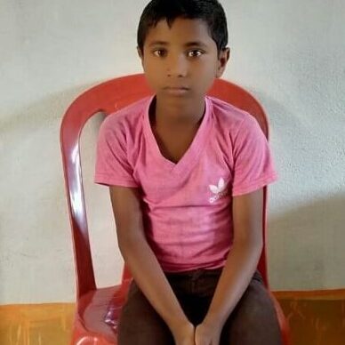 A young boy sitting on top of a red chair.