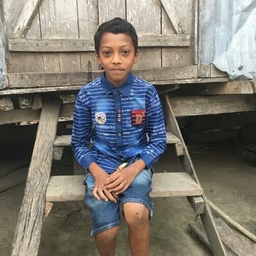 A young boy sitting on top of wooden steps.