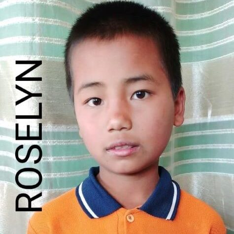 72 A young boy with blue eyes and an orange shirt.