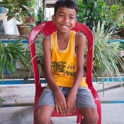 A boy sitting on top of a red chair.