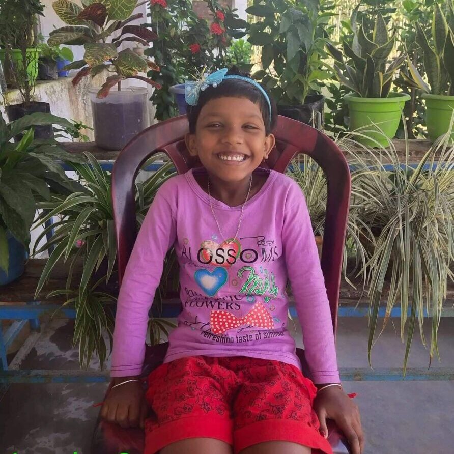 A young girl sitting on top of a chair.