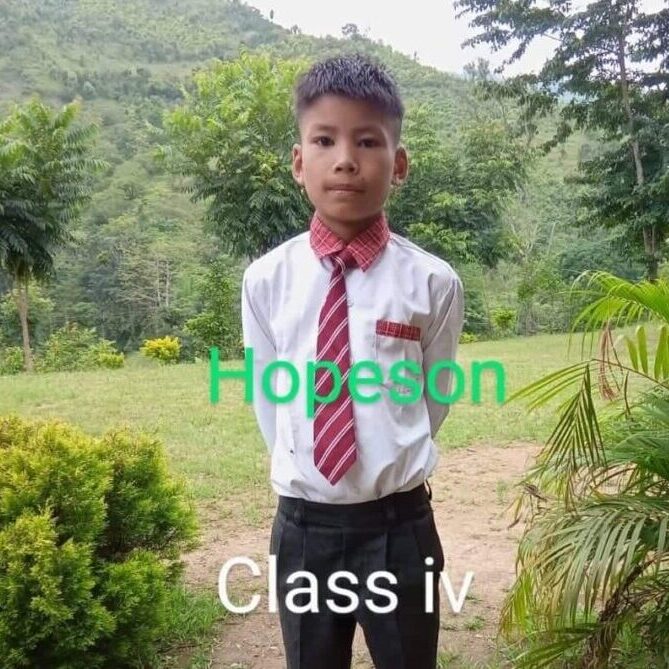 A young boy in a tie and shirt standing outside.