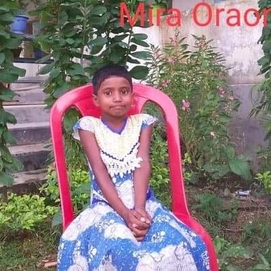 A young girl sitting in a chair outside.