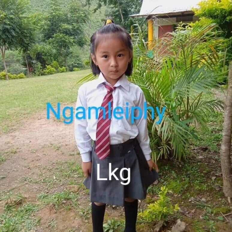 A girl in school uniform standing outside.