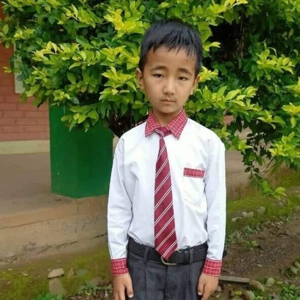 A young boy in a tie and dress shirt.