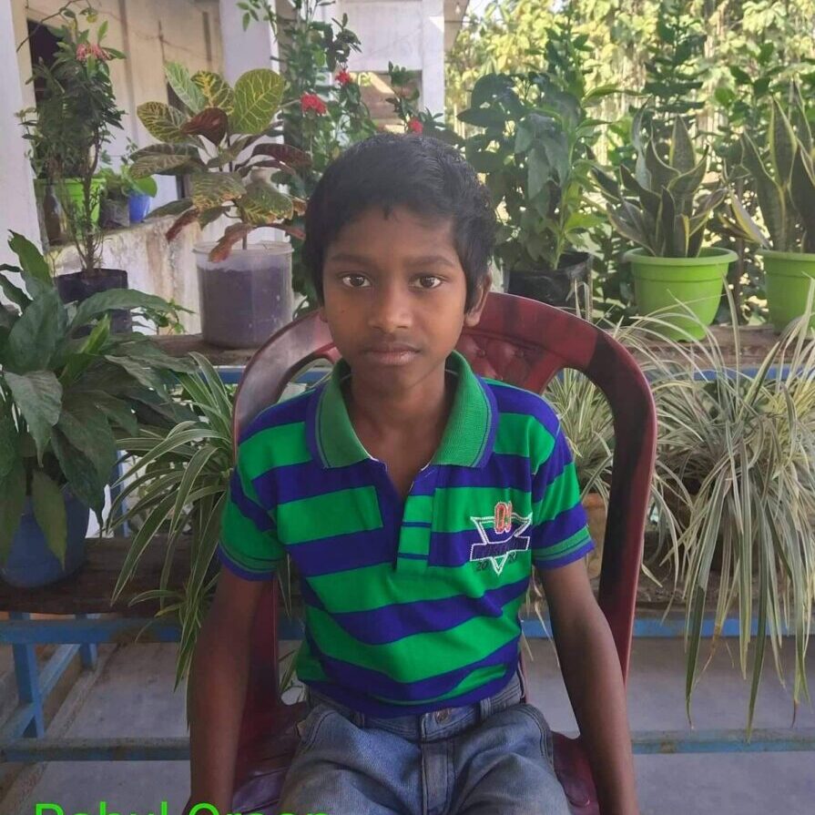 A young boy sitting in a chair outside.