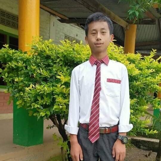 Shanchuipam Mungshang Class VII A young man in a tie standing next to a tree.