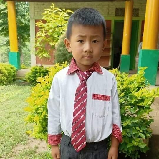 A young boy wearing a tie and dress shirt.